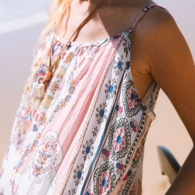 Blusa florida de tecido leve com alças finas em ambiente de praia