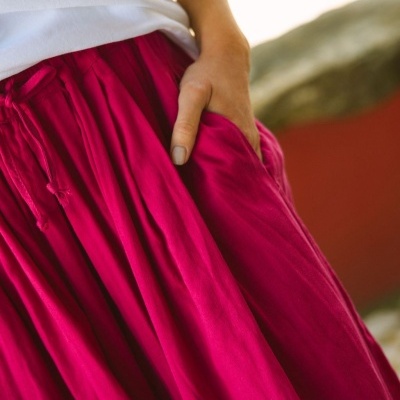 Saia comprida fúcsia com bolsos e cordão na cintura usada com t-shirt branca