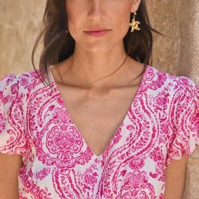 Blusa branca com estampado floral rosa e decote em V com mangas curtas franzidas.