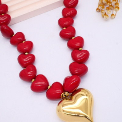 Colar com contas vermelhas e pendente dourado em forma de coração