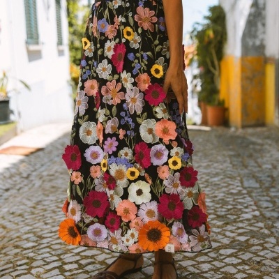 saia preta com flores bordadas coloridas usada com sandálias castanhas