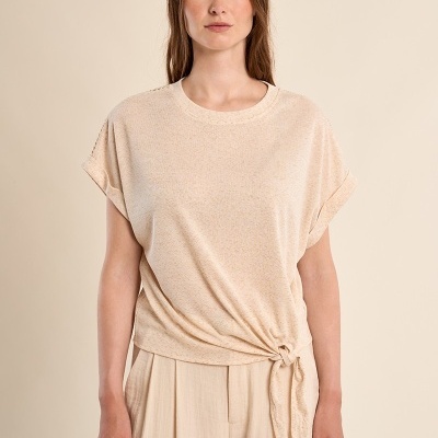 Blusa bege clara com nó lateral usada por mulher com calças largas bege