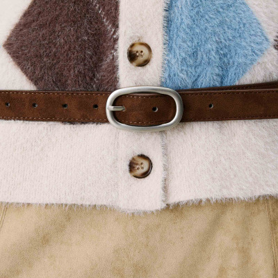 Peça de vestuário felpuda com padrão em creme, azul e castanho, botões castanhos e cinto castanho com fivela metálica prateada.
