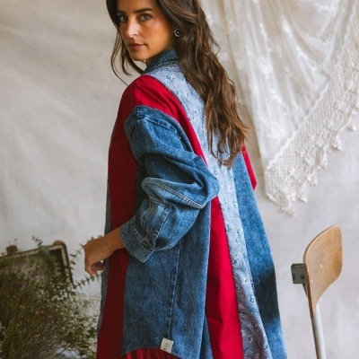 Casaco oversize tecido azul denim, vermelho e azul claro padrão floral usado por mulher com saia vermelha.
