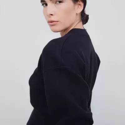 Mulher com camisola preta e calças de ganga