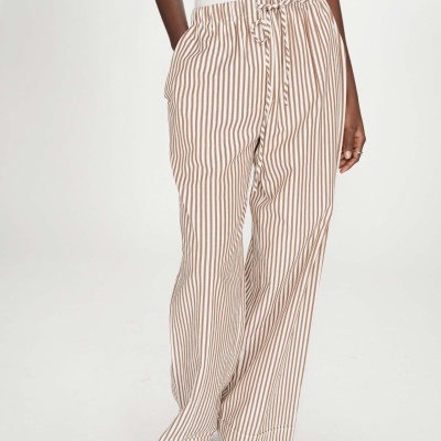 Calças de riscas castanhas e brancas com cintura elástica e cordão, usadas com sandálias pretas