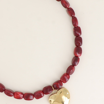 colar de contas vermelhas com pendente dourado em forma de coração