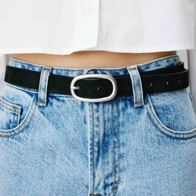 Cinto preto com fivela prateada em jeans e camisa branca