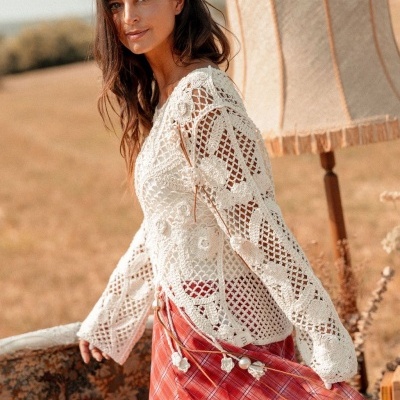 Mulher com camisa crochet branca e saia vermelha xadrez ao ar livre