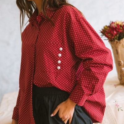 Camisa vermelha com bolinhas brancas e botões de pérola na manga