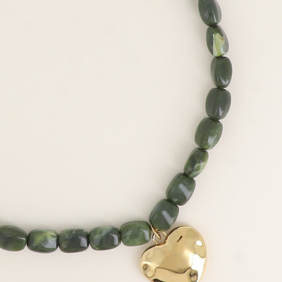 Colar verde com pendente dourado em forma de coração