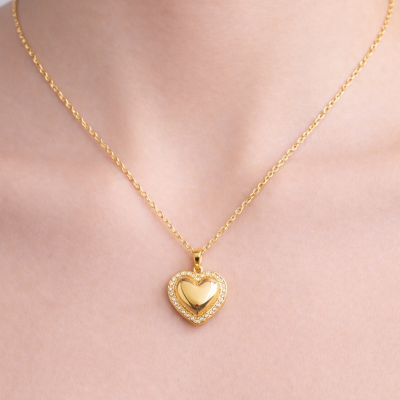 Colar dourado com pendente em forma de coração com pedras brilhantes