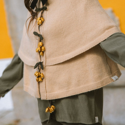 Blusão de malha castanho claro com flores douradas aplicado, camisa verde-oliva e calças combinando
