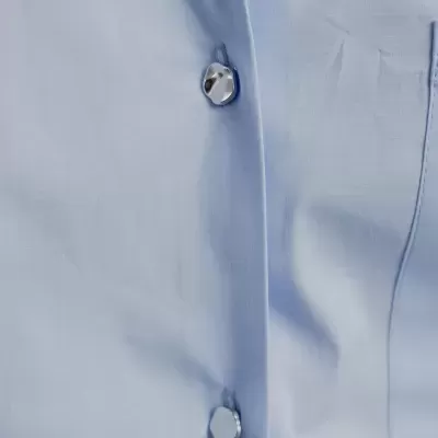 Camisa azul clara com botões prateados hexagonais