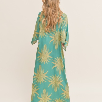 Vestido verde com estampado dourado, modelo visto de costas