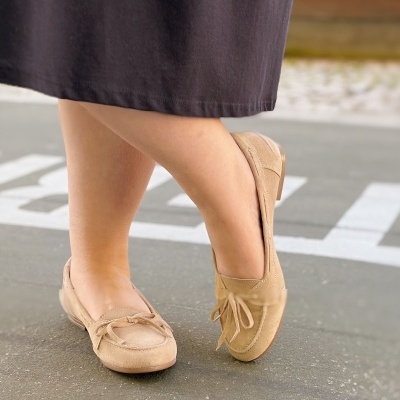 Mocassins bege em camurça com laço usados com vestido preto
