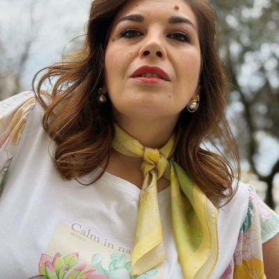 Mulher com lenço amarelo e t-shirt branca com estampa floral e texto