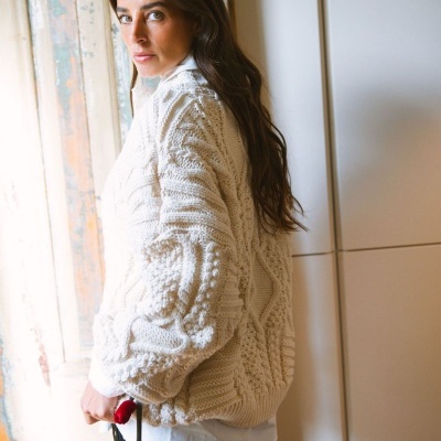 Mulher a usar camisola de malha branca grossa com padrão trançado