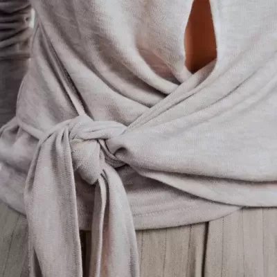 Parte superior cinza com nó frontal e calças bege com risca de giz