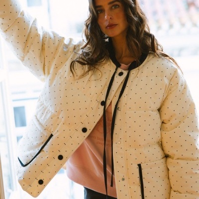 Casaco acolchoado branco com pequenos pontos pretos e botões pretos