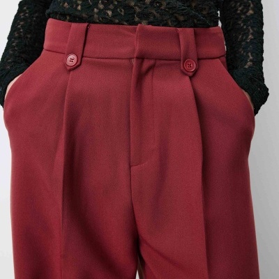 Calças vermelhas de tecido com blusa preta de renda floral