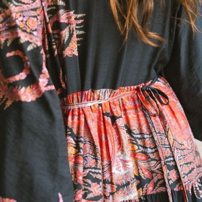 Vestido feminino preto com padrão floral vermelho e cinto fino na cintura