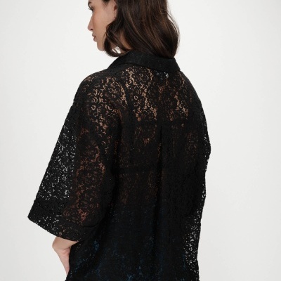 Camisa preta de renda com padrão floral e gola clássica vista de costas.