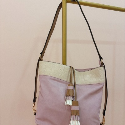 Mala de ombro rosa claro com detalhe bege e franjas decorativas