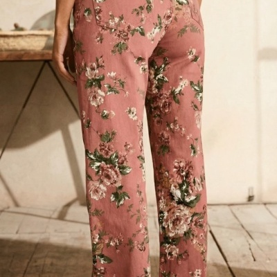 Calças rosas florais usadas por trás com sandálias castanhas