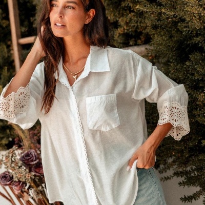 Camisa branca feminina com gola e mangas rendadas em ambiente exterior