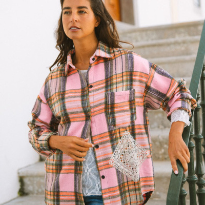 Casaco xadrez rosa com bolso e aplique de renda em modelo junto a escadas externas