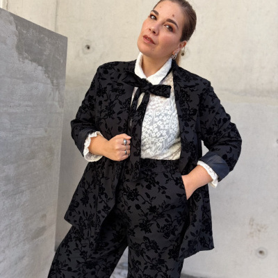 Conjunto feminino com blusa branca de renda e casaco preto com padrão floral