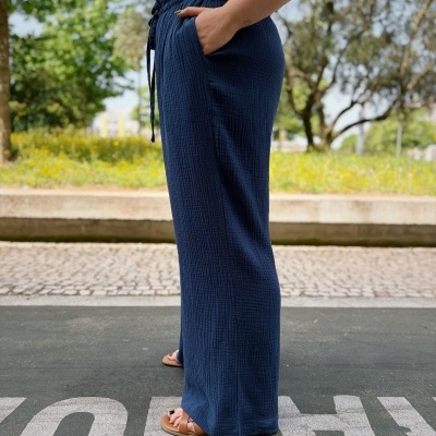 Calças femininas azuis com top amarelo em ambiente exterior