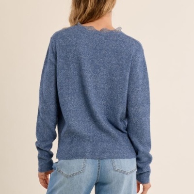 Pessoa de costas com camisola azul de malha e calças de ganga claras