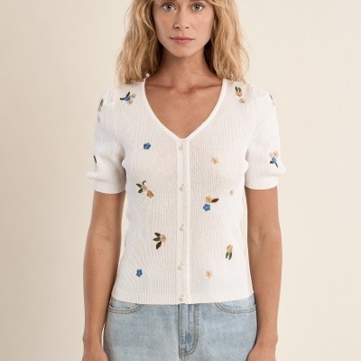 Cardigã branco com botões e bordados florais usado com calças de ganga claras