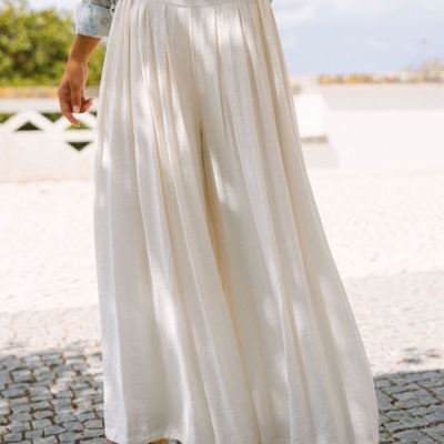 Saia longa branca plissada com blusa floral e sandálias de cunha