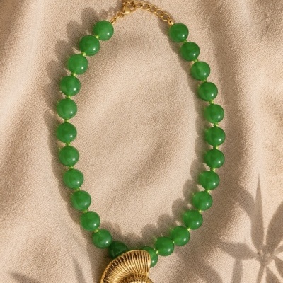 Colar com contas verdes e pendente dourado em forma de concha