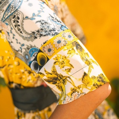 Manga de blusa ou vestido com estampado floral colorido e cinto preto
