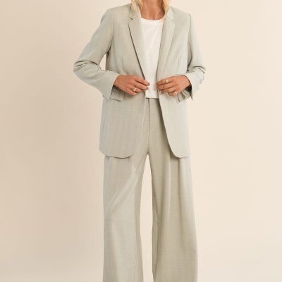 Conjunto de blazer e calças largas cinza claro com camisa branca e sapatos brancos