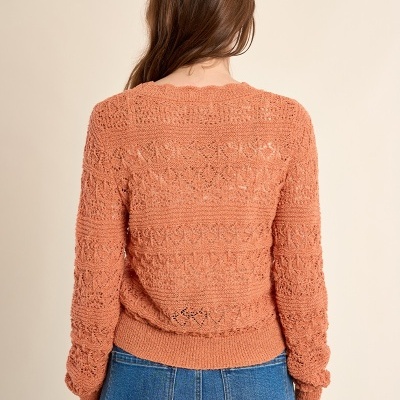 Camisola tricotada cor de ferrugem vista de costas com calças de ganga azuis