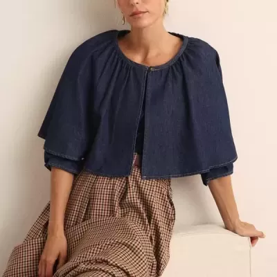 Mulher sentada a usar casaco denim azul escuro e vestido comprido xadrez castanho