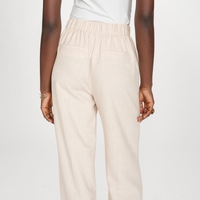 Calças compridas cor creme com cintura elástica vistas de trás.
