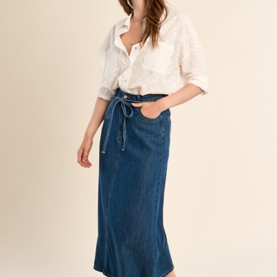 Mulher com camisa branca de algodão e saia longa de ganga azul