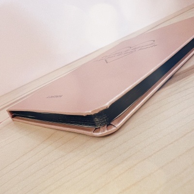 Pasta fina cor-de-rosa com ilustração em linha sobre superfície de madeira.