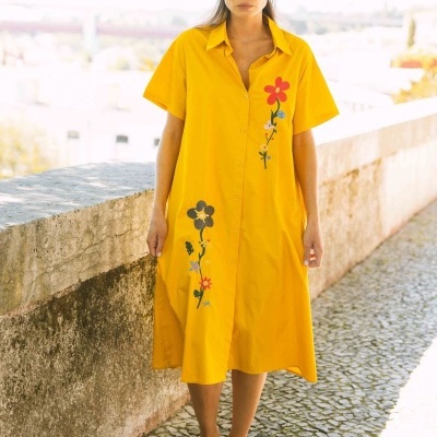 Vestido amarelo com estampas florais usado por mulher em exterior