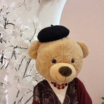 Urso de peluche vestido com roupa elegante e boina preta em ambiente decorado