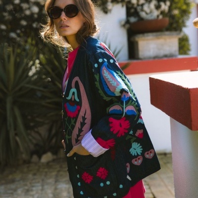 Casaco feminino com bordados florais coloridos e óculos de sol redondos