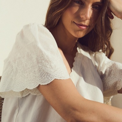 Blusa branca com mangas bordadas e detalhe em ondas na beira da manga