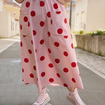 Saia rosa com bolinhas vermelhas, cinto preto e ténis rosa claros