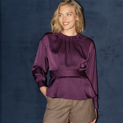 Modelo com blusa roxa acetinada e calções pied-de-poule